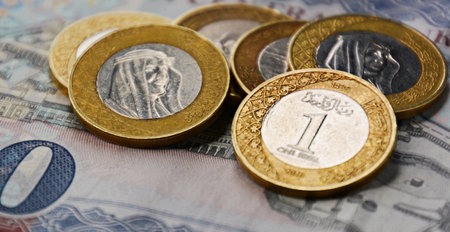 saudi coins on the background of the ruble banknote close up