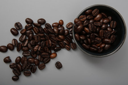 close-up of brown coffee beans in a bowl, coffee beans background, coffee beans in a bowl on wooden...