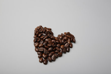 Coffee beans in a wooden scoop and spilling out from a hessian bag,