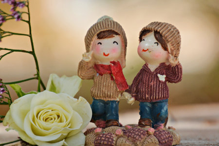 Cute figurines of a bride and groom share a romantic kiss atop