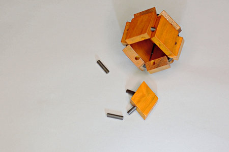 Logical puzzle game wooden cube puzzle in collected form on a yellow background with copy space....