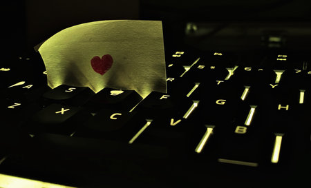 small red hearts and sticky note on Laptop keyboardの写真素材