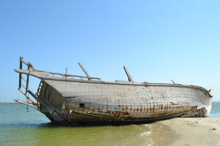 Ruined wreck of a fishing boat stranded on a sandy beach.の写真素材