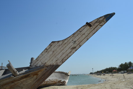Ruined wreck of a fishing boat stranded on a sandy beach.