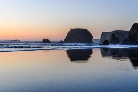 The sun sets on a tranquil beach on the Oregon coast along the Pacific Coast Highwayの写真素材