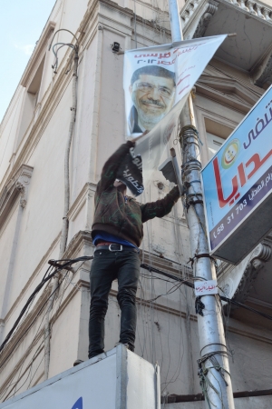 Alexandria, Egypt - December 7, 2012 -Egyptian demonstrator tearing down a poster of President Morsiのeditorial素材