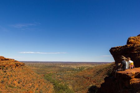 KINGS CANYON, AUSTRALIA; May 5, 2015: young people enyoing view of the Kings Canyon and sitting on the edge of a cliff,, Watarrka National Park, Northern Territory, Australiaのeditorial素材