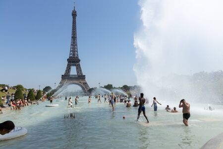Paris, France, June 27, 2019: tourists and locals taking a bath in the Jardins du Trocad ro Guardians of the Trocadero under the powerful water cannons. new heat records over 45 degrees celiusのeditorial素材
