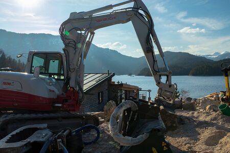 Eibsee, Germany, March 31, 2019: a large excavator on a constructions site before the tourist season is startingのeditorial素材