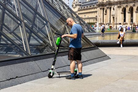 Paris, FRANCE - June 27, 2019: a man with Lime electric scooters, rented through a mobile app and...