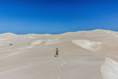 young man walking on endless and wide sand dunes, Nullabor Dessertの写真素材