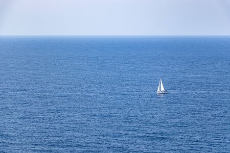 beautiful sailboat sailing in the distance in blue Mediterranean sea ocean, mallorcaの写真素材