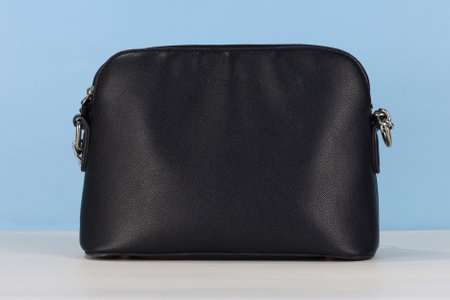 Black leather female bag on blue backgroundの写真素材