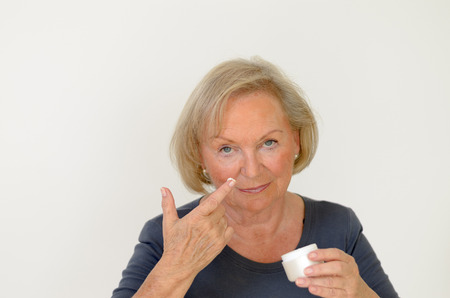 Attractive middleaged woman applying creamの写真素材