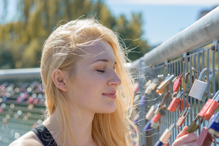 Beautiful young blond woman holding padlocks as a sign for endless love
