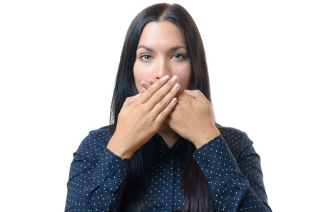 Serious young woman with long black hair covering her mouth with her hand in a Speak No Evil...