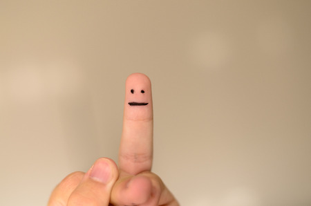 Neutral face hand drawn on a finger tip isolated on a neutral background with copy spaceの写真素材