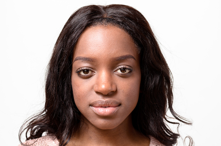 One beautiful young African woman with stray hair and serious expression and blank stareの写真素材