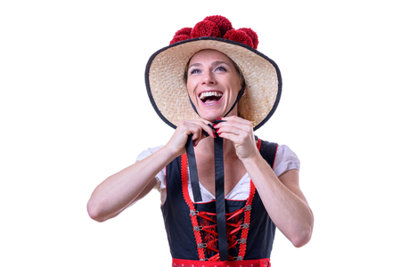 Attractive young woman binding her Black Forest traditional dress with a Bollenhut adorned with 14 red pompomsの写真素材