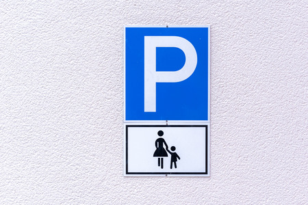 Parking sign for mothers with young children on a textured white exterior wallの写真素材