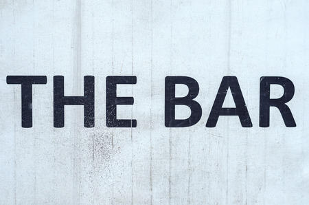 Old grunge sign - The Bar - in black and white with dirt and staining on the surface
