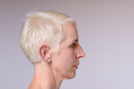 Side close up Portrait of a middle aged woman with a neutral lookの写真素材