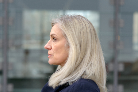 Profile portrait of an attractive middle-aged woman with shoulder length hair looking off to the left of the frameの写真素材