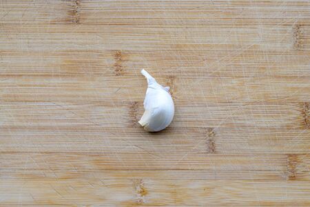 Fresh garlic bulb on a wooden table as a pungent flavoring in cooking in a top down view with...