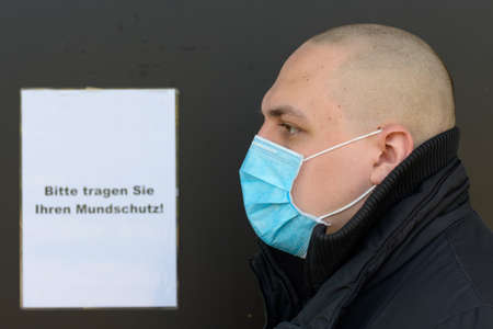 Profile of a young man wearing a face mask for infection control during the Covid-19 pandemic...