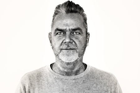 Middle aged man with modern hairstyle  looking at the camera with a serious expression in black and...