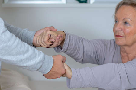 Hands helping an old Lady to get up, focus on hands