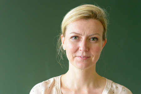 Close-up portrait of female teacher in class in  front of a chalkboard with friendly face