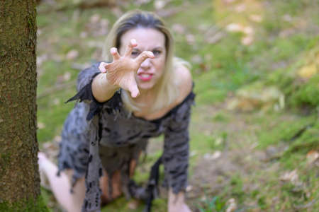 Anguished woman screaming and reaching up to the camera clawing with her hand and focus on hand