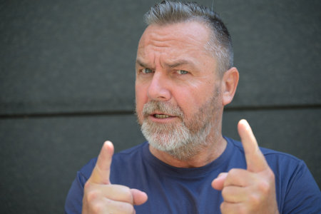 Argumentative man making a point wagging his fingers at the camera as he speaks in close up