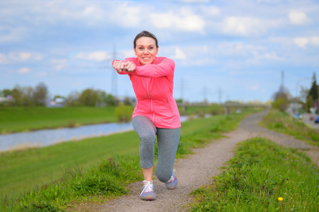 Attractive blond woman stretching before jogging