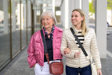 Close uo of a mother and daughter shopping in a mall, walking and looking to sideの写真素材