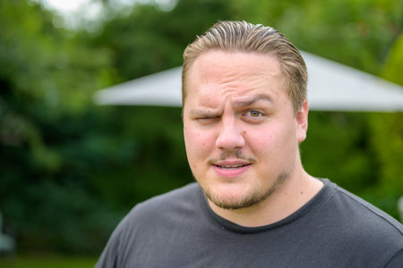 Young man showing total disbelief and scepticism as he raises an eyebrow at the camera