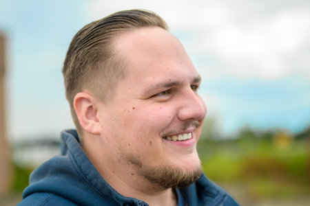 A close-up portrait of a smiling man, captured with a relaxed expression and gentle eyes.の写真素材