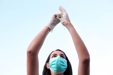 Portrait of a young caucasian girl wearing a corona virus protection mask and putting on protective...