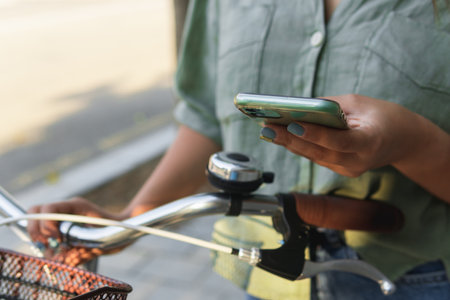 Close-up of a young girl using her smart phone on a bicycle