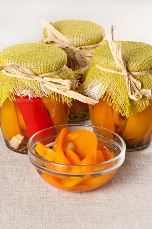 Marinated paprika in jars and in a bowlの写真素材