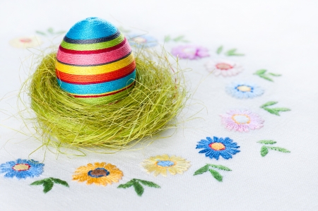 Handmade Easter decorations on an embroidered tableclothの写真素材