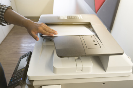 Man copying paper from Photocopier sunlight from windowの写真素材