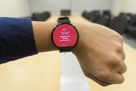 business man look smartwatch Leather watchbands black color circle front on left hand at meeting room show agenda schedule when where and organizerの写真素材