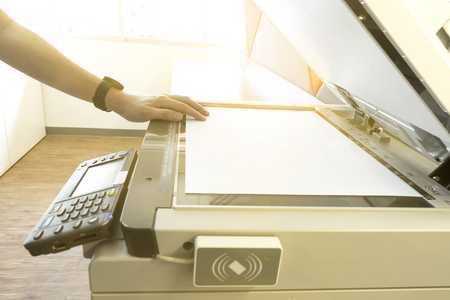 Man copying paper from Photocopier with access control for scanning key card sunlight from windowの写真素材