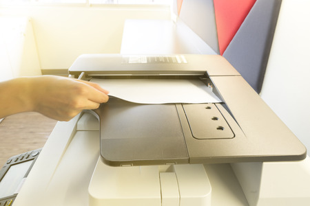 Man copying paper from Photocopier with access control for scanning key card sunlight from windowの写真素材