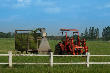 Tractor with mowing machine lawn mower at farmの写真素材
