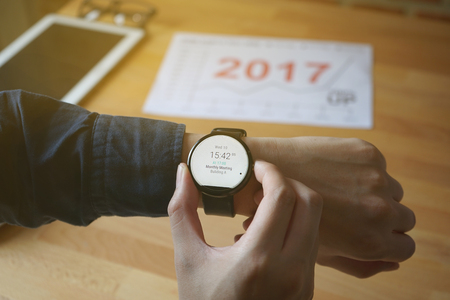 business man look smartwatch for checking time to meeting at coffee shopの写真素材