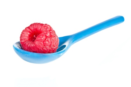 Raspberry in a blue little spoon over a white backgroundの写真素材