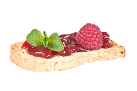 Roasted bread with jam or marmelade garnished with mint and raspberry